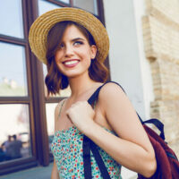 Smiling woman with hat and backpack