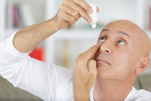 Man putting drops in eyes