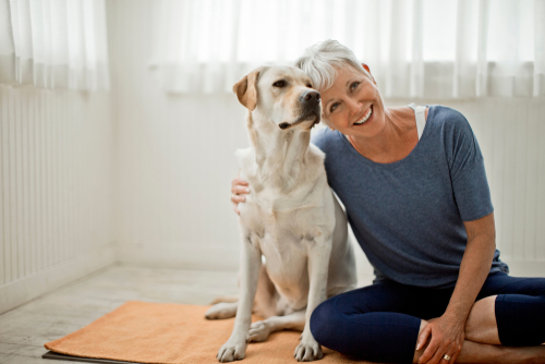 Older woman with cataracts smiling with her dog