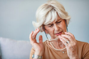 Woman taking glasses off in distress