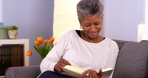 woman sitting on couch while reading book