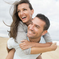 Young couple on beach smiling