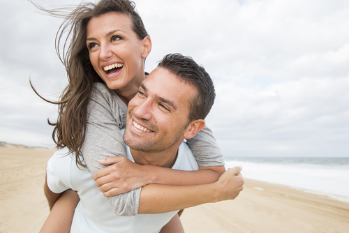 Young couple on beach smiling