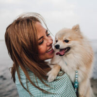 Young woman holding a dog with cataracts