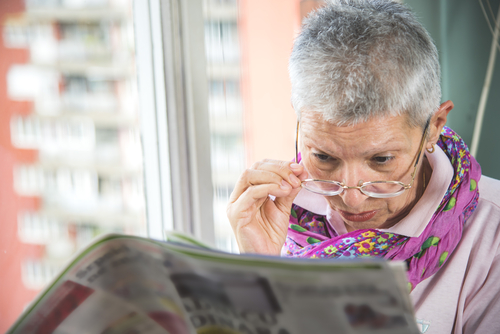 Senior woman reading paper with glasses