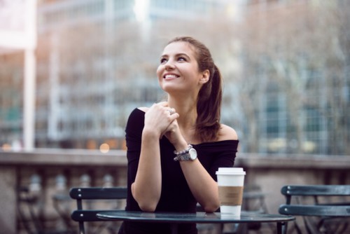 Young woman with coffee, smiling